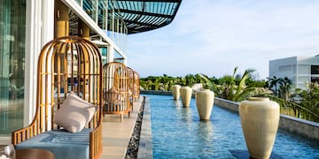 a pool of water with chairs and large vases