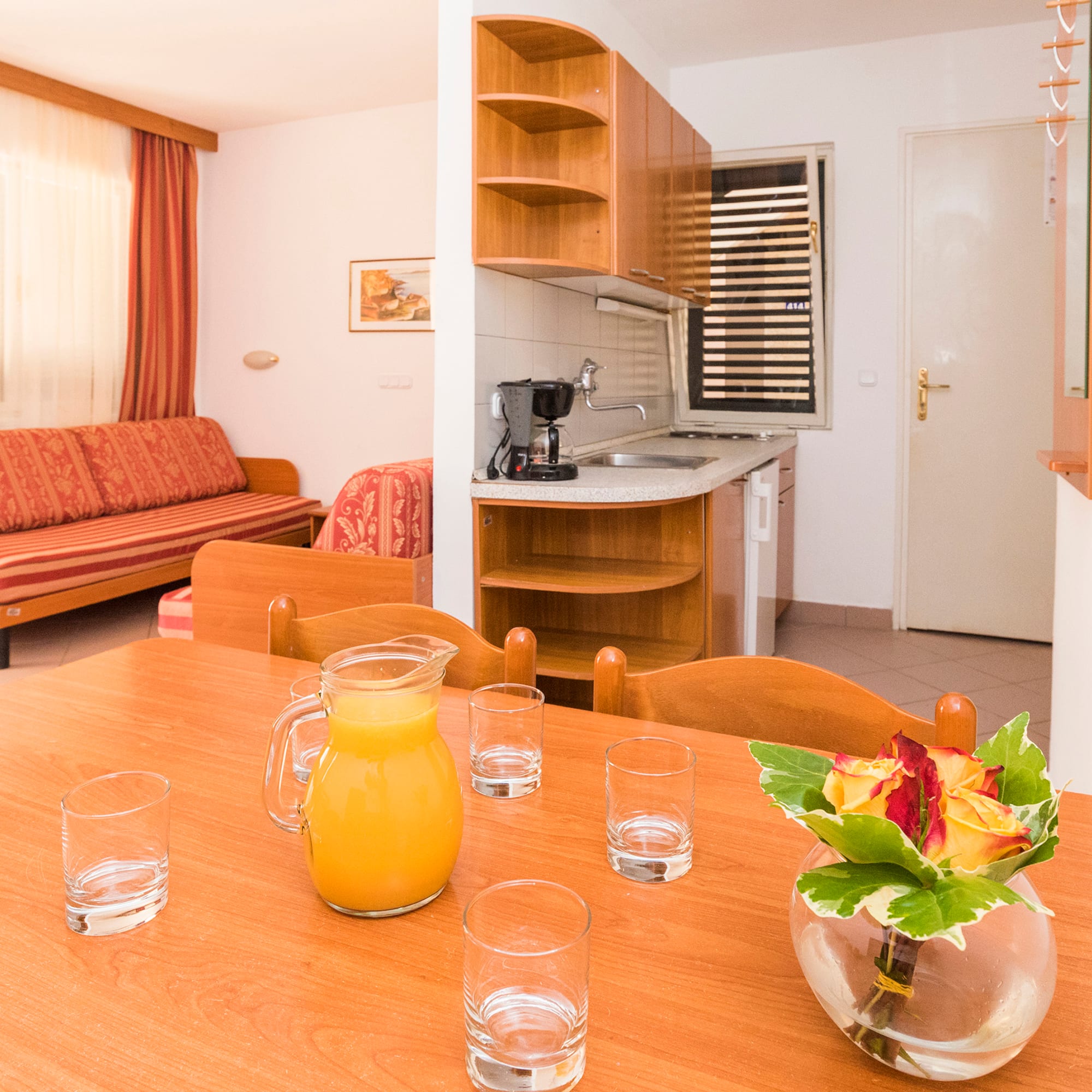 a table with glasses and a vase of juice on it