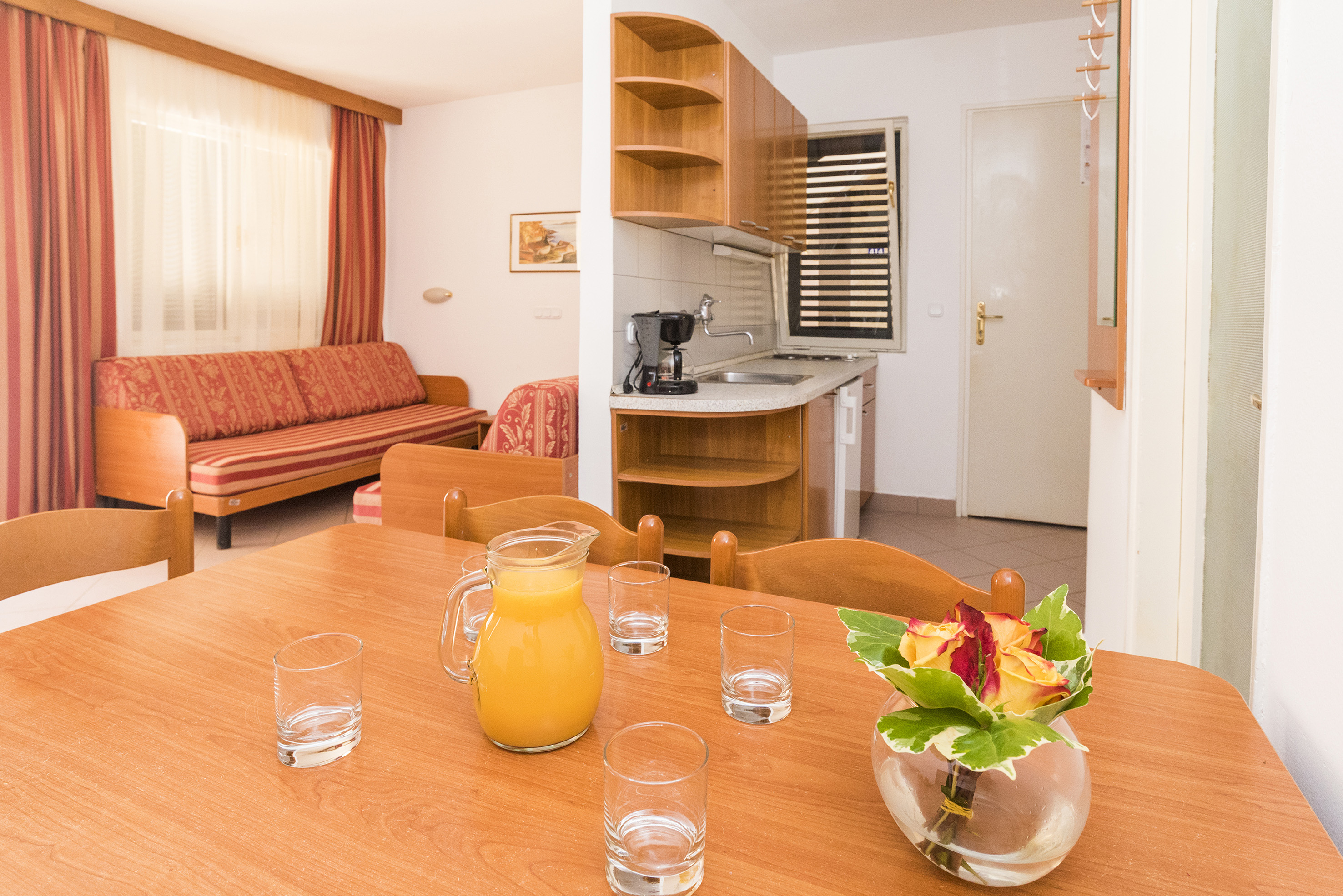 a table with glasses and a vase of juice on it