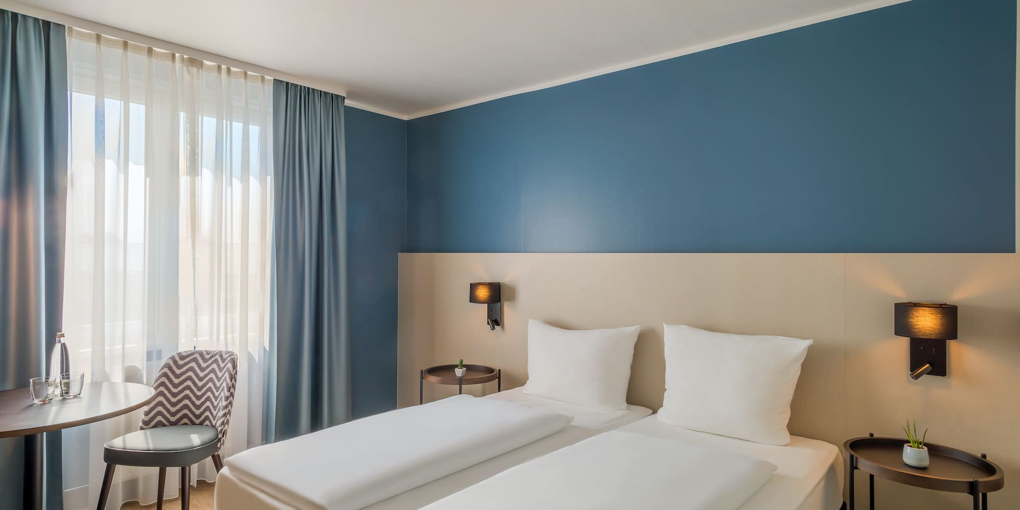 a room with two beds and a chair