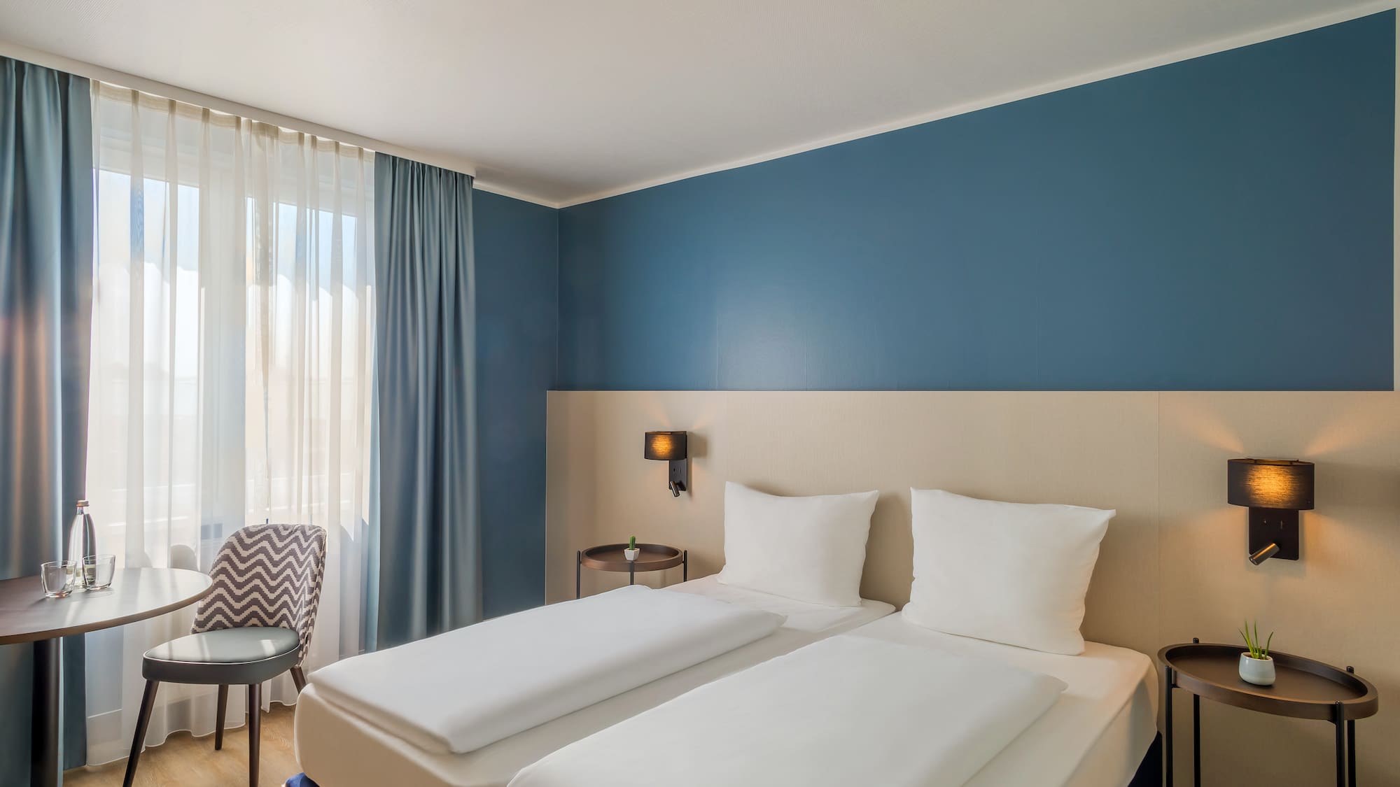 a room with two beds and a chair