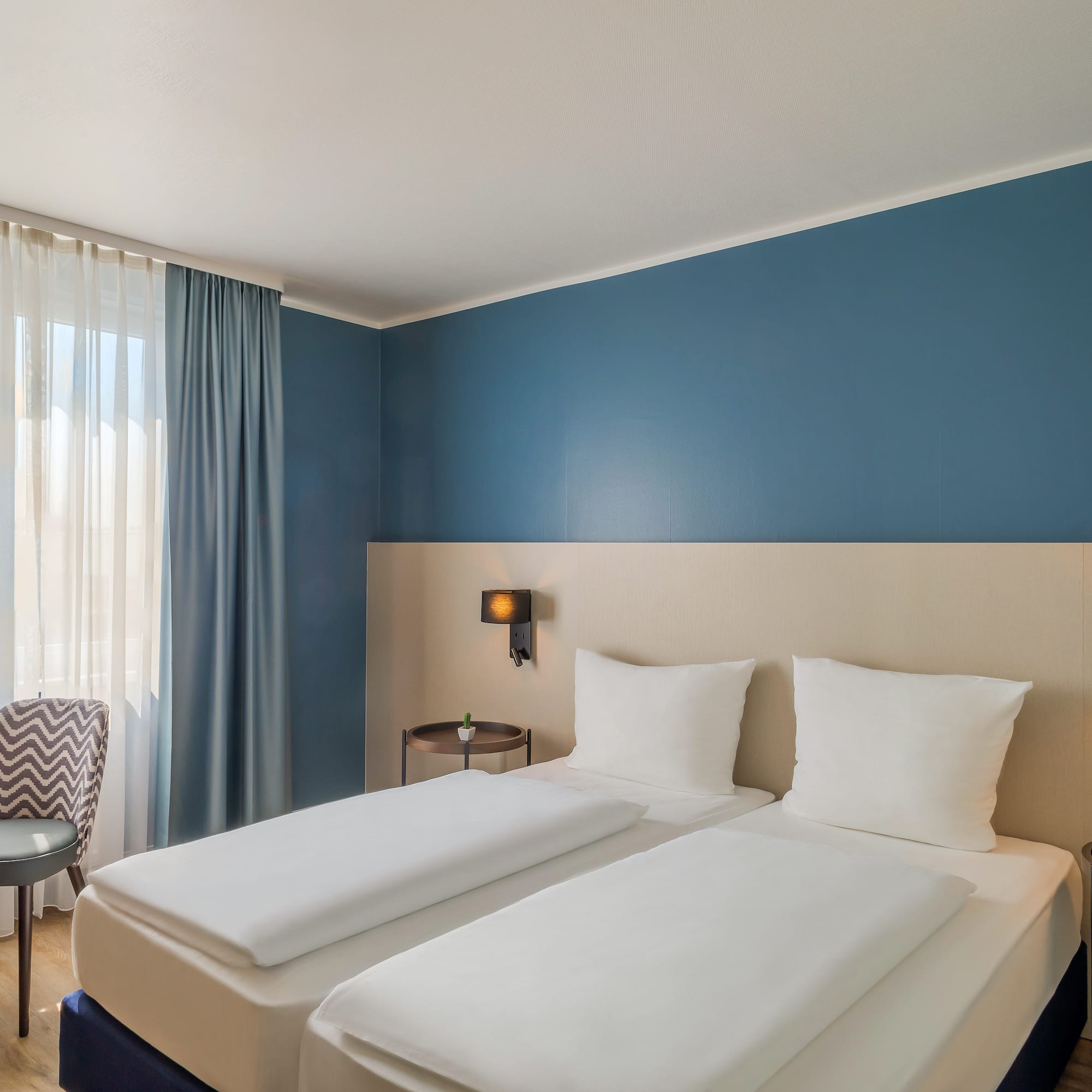 a room with two beds and a chair