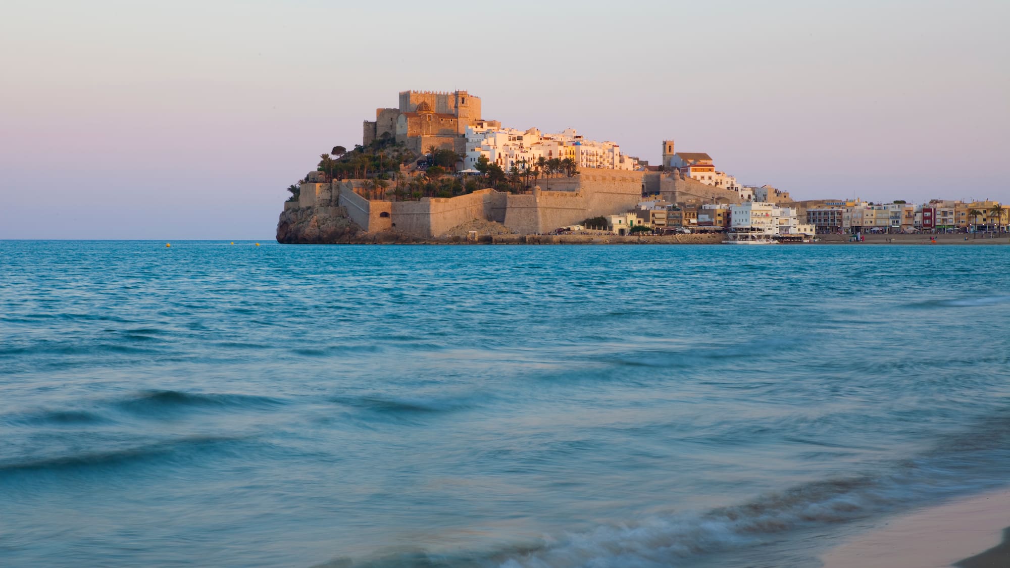 a castle on a hill in the middle of a body of water