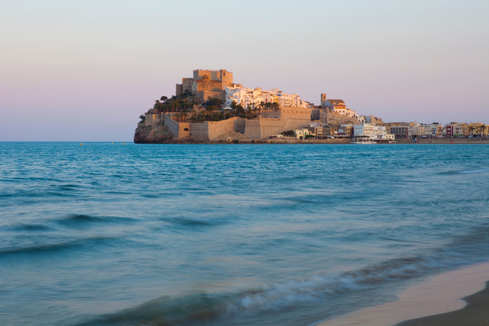 a castle on a hill in the middle of a body of water