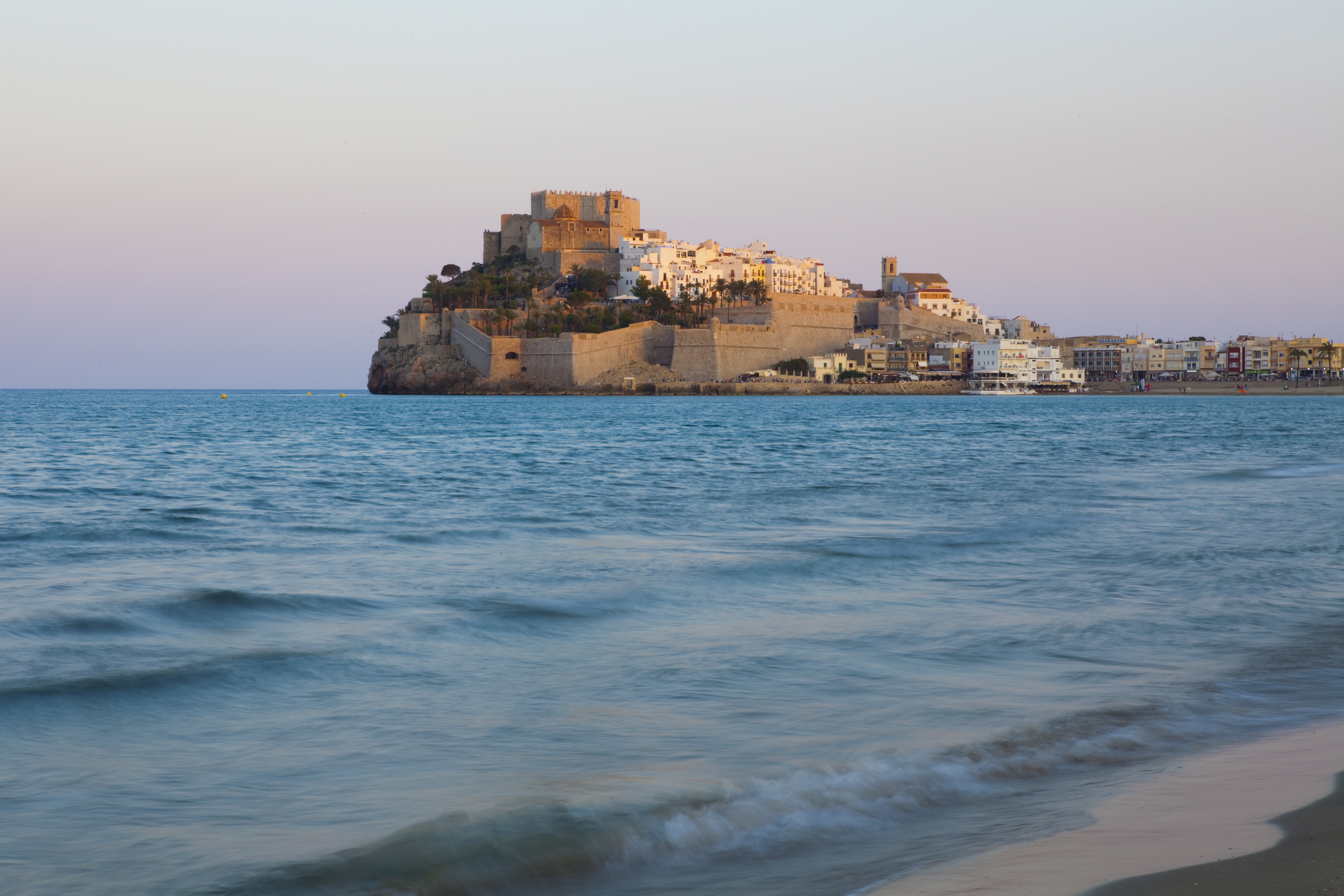 a castle on a hill in the middle of a body of water