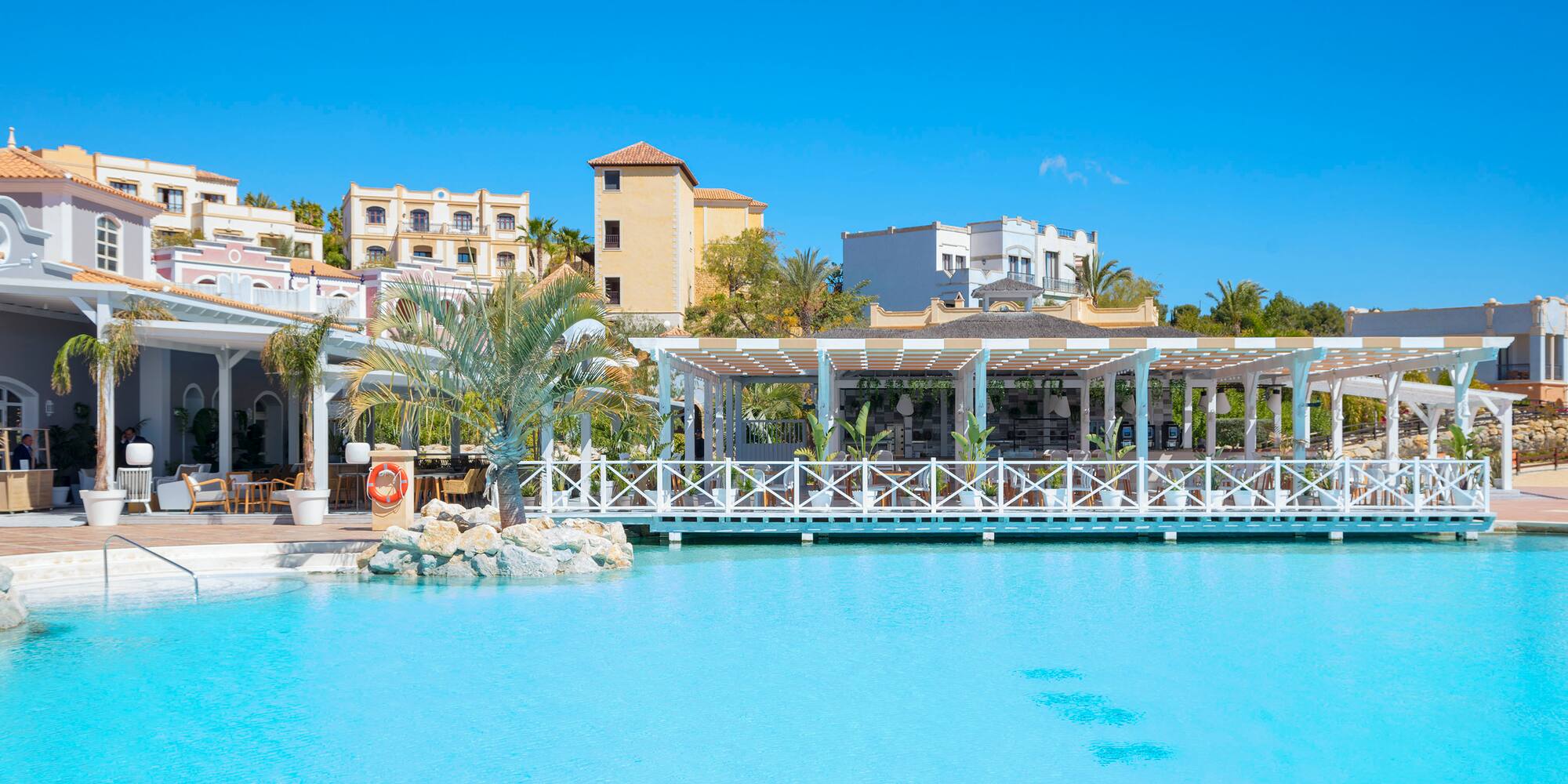 a pool with a white structure and palm trees