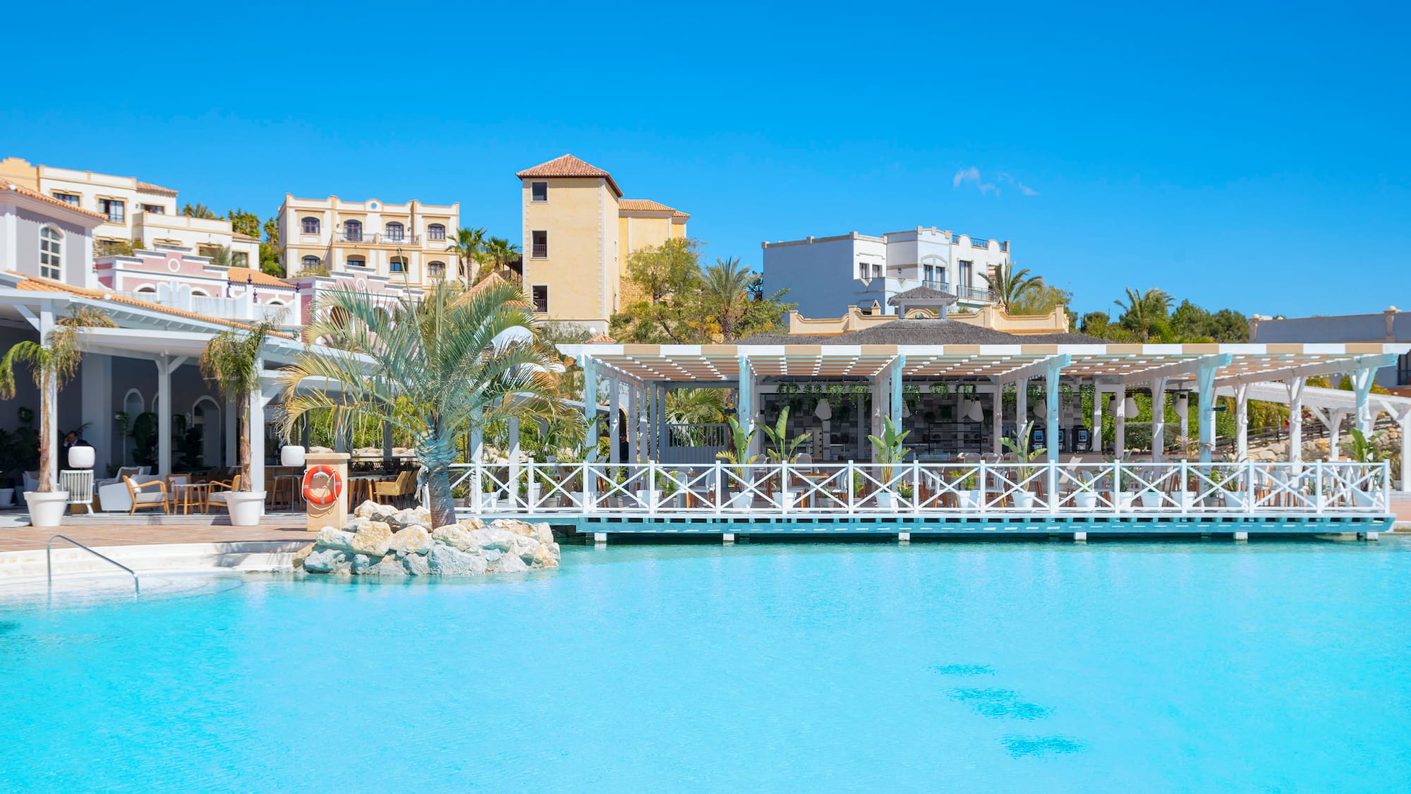a pool with a white structure and palm trees