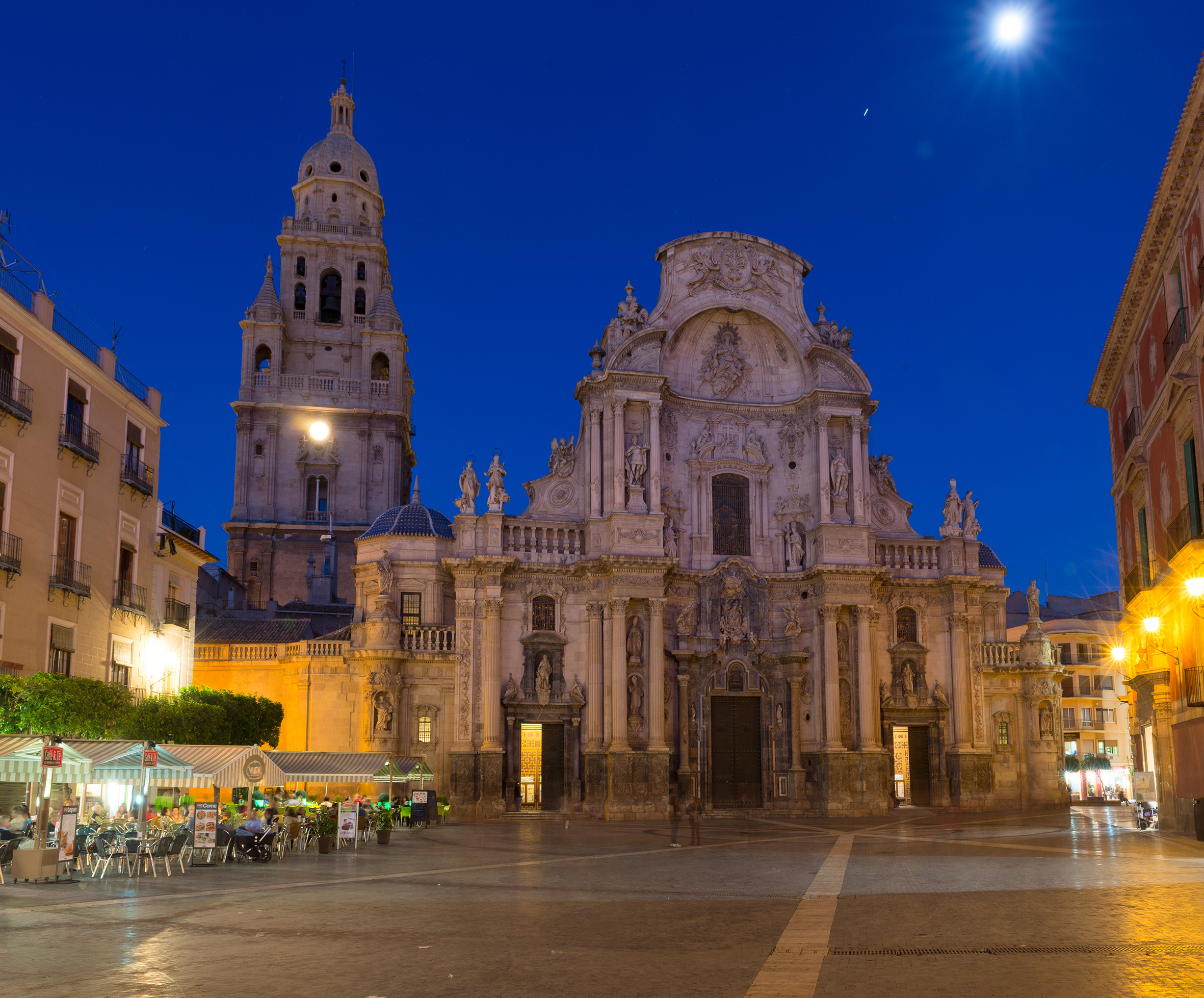 Baroque Murcia Cathedral and bell tower illuminated at night in a Spanish plaza.