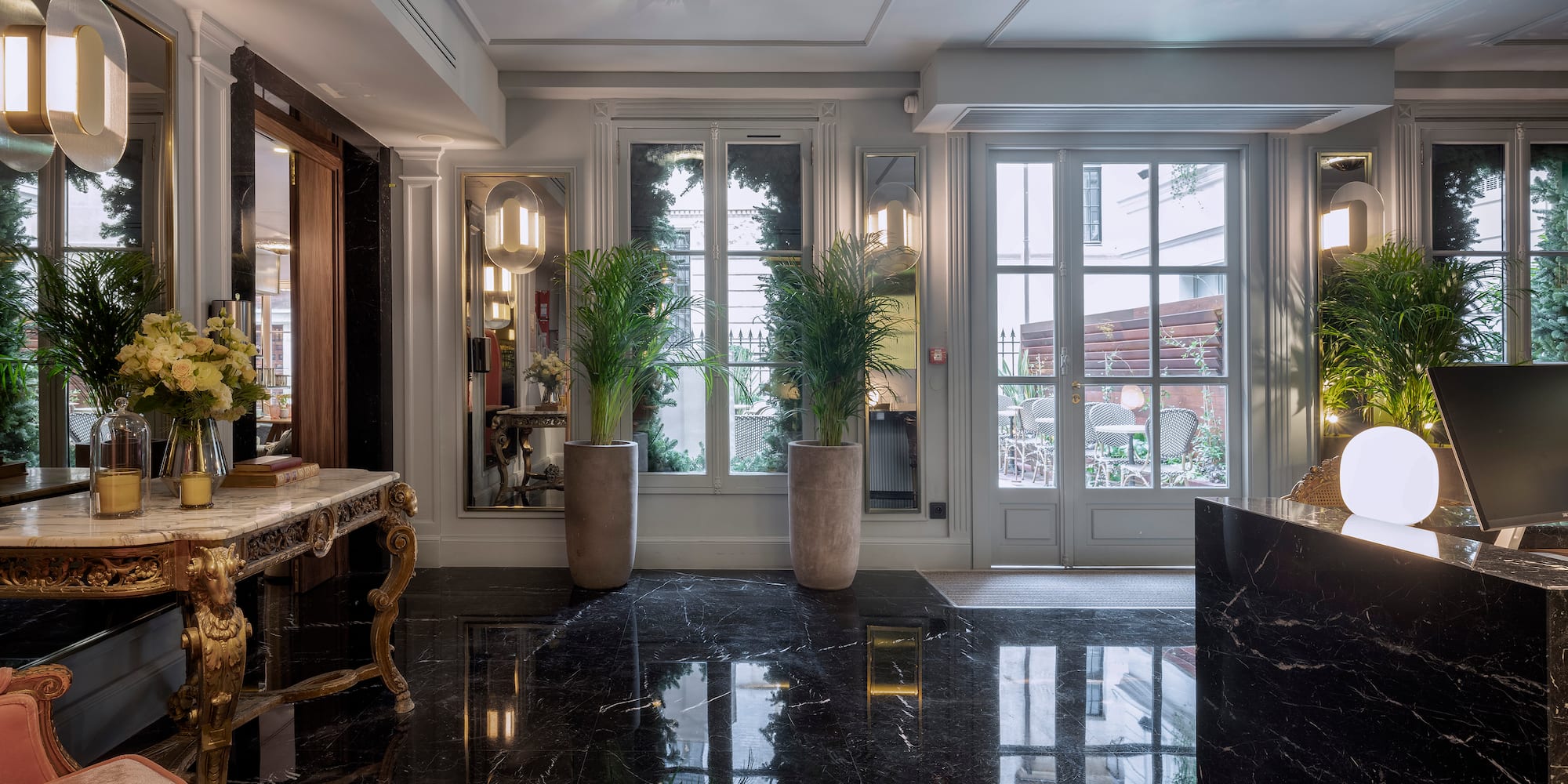 a black marble floor with a marble table and plants in front of it