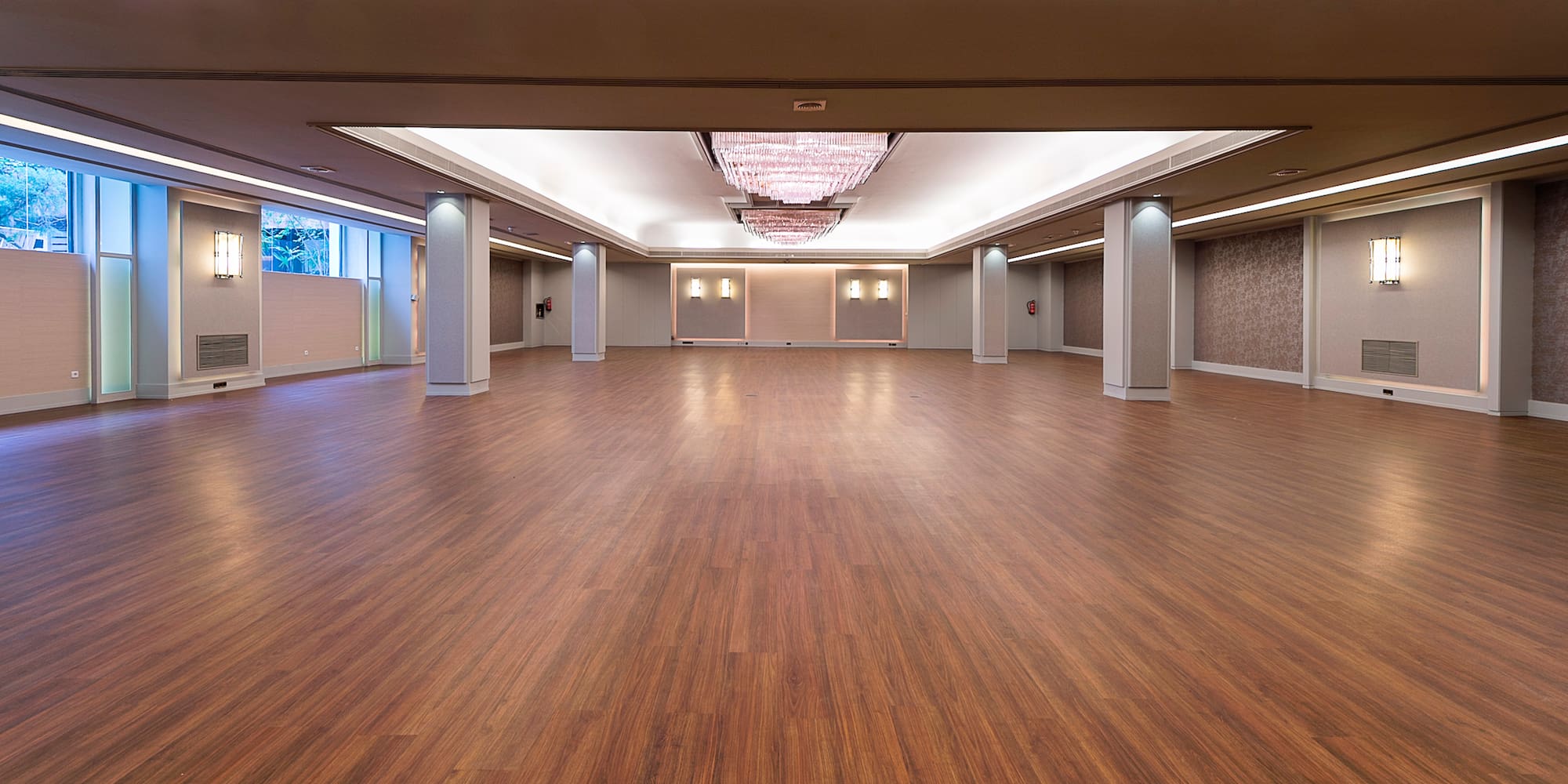 a large room with wood floors and ceiling lights