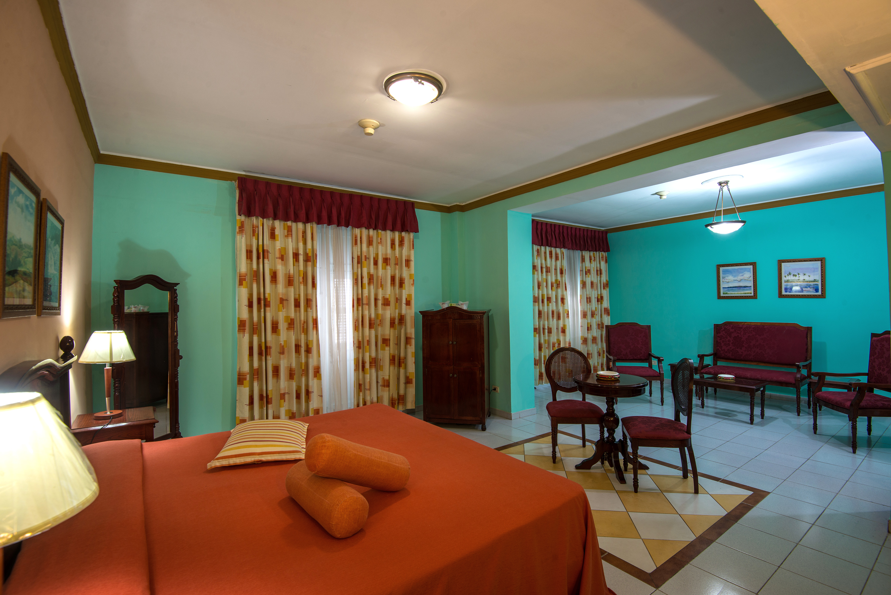 a room with a bed and chairs