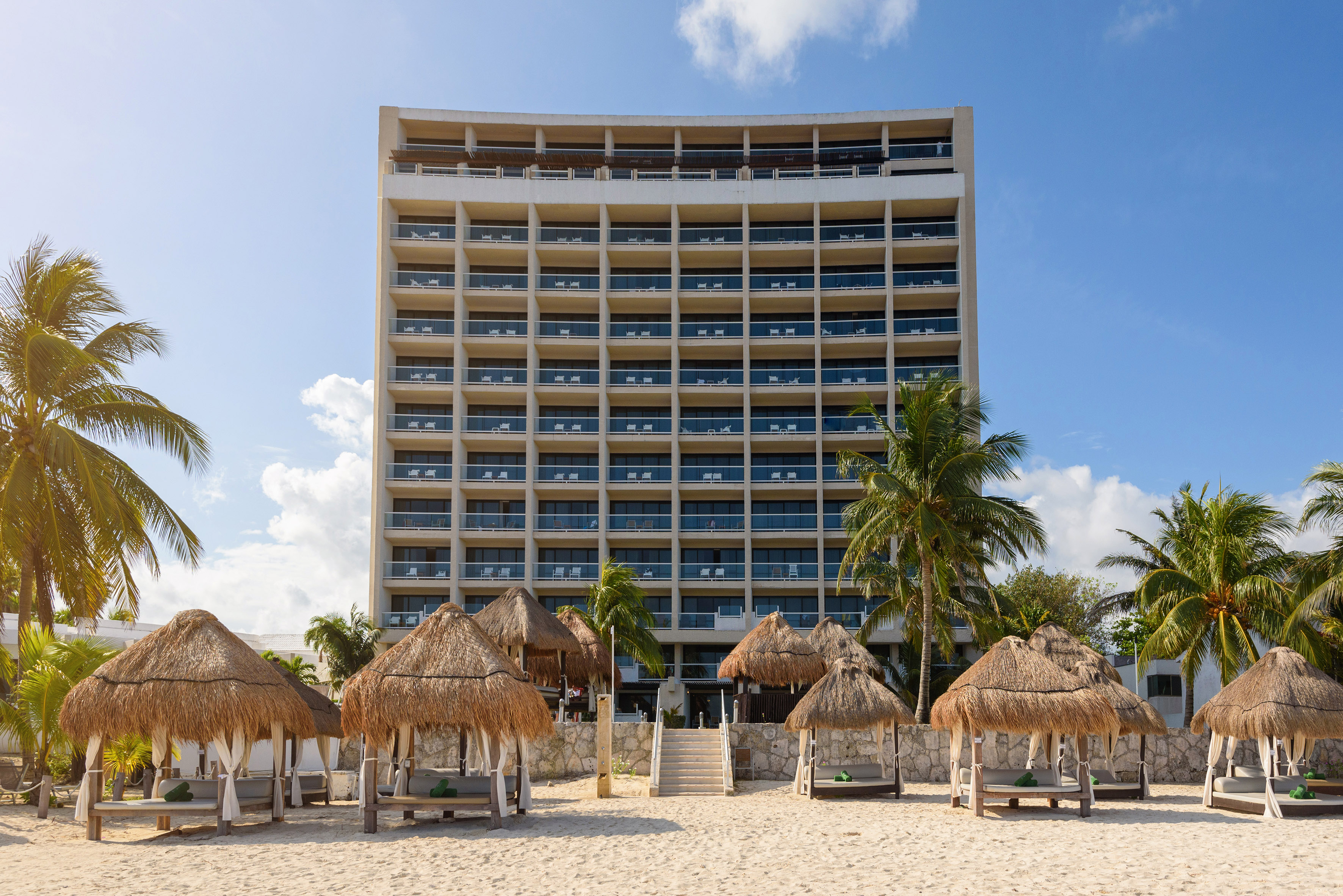 a building with a beach and palm trees