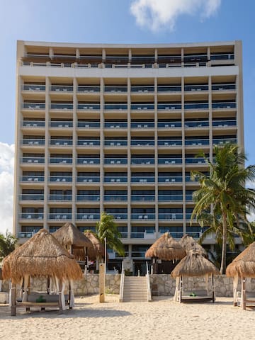 a building with a beach and palm trees
