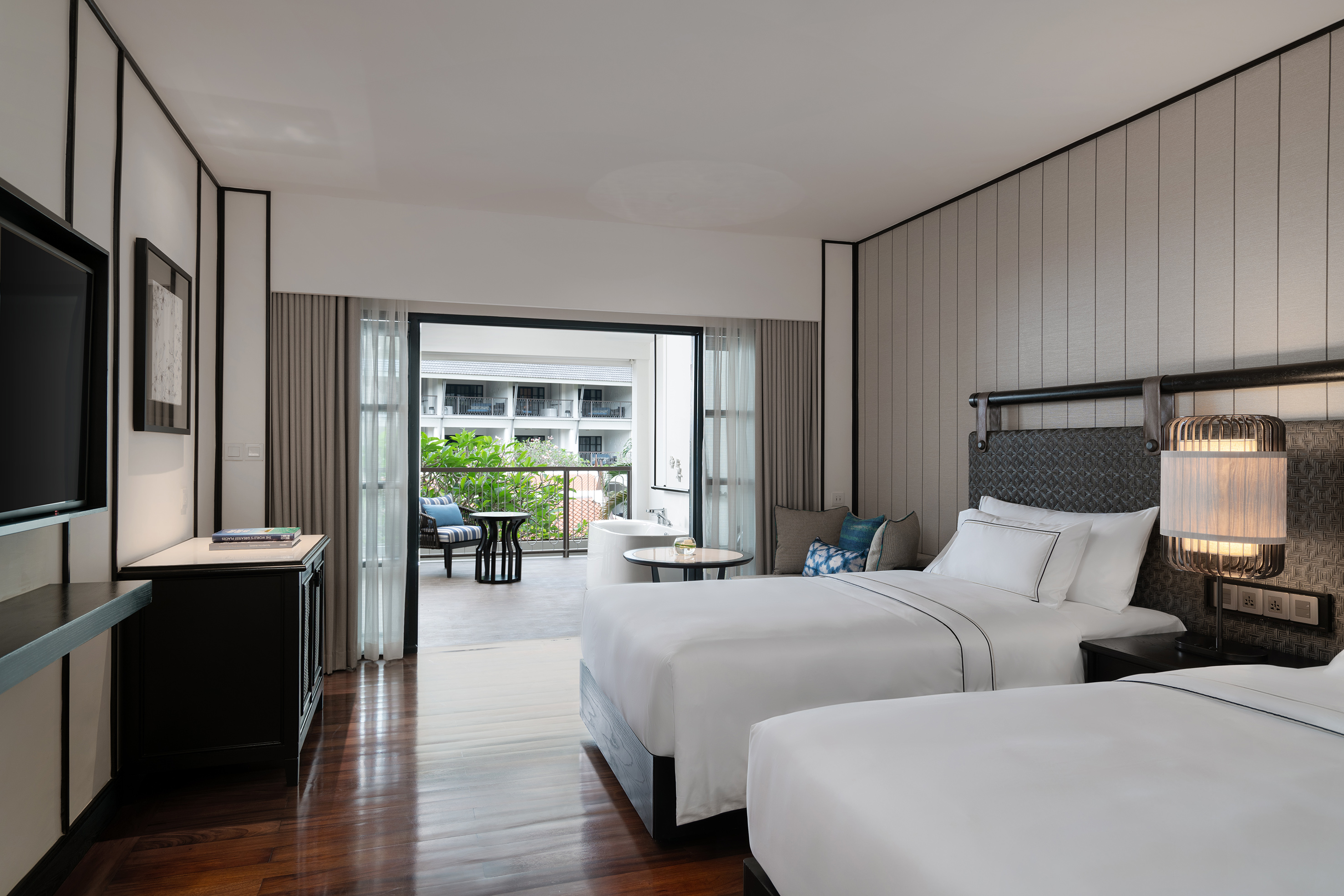 Luxury hotel twin room with private balcony and resort view.