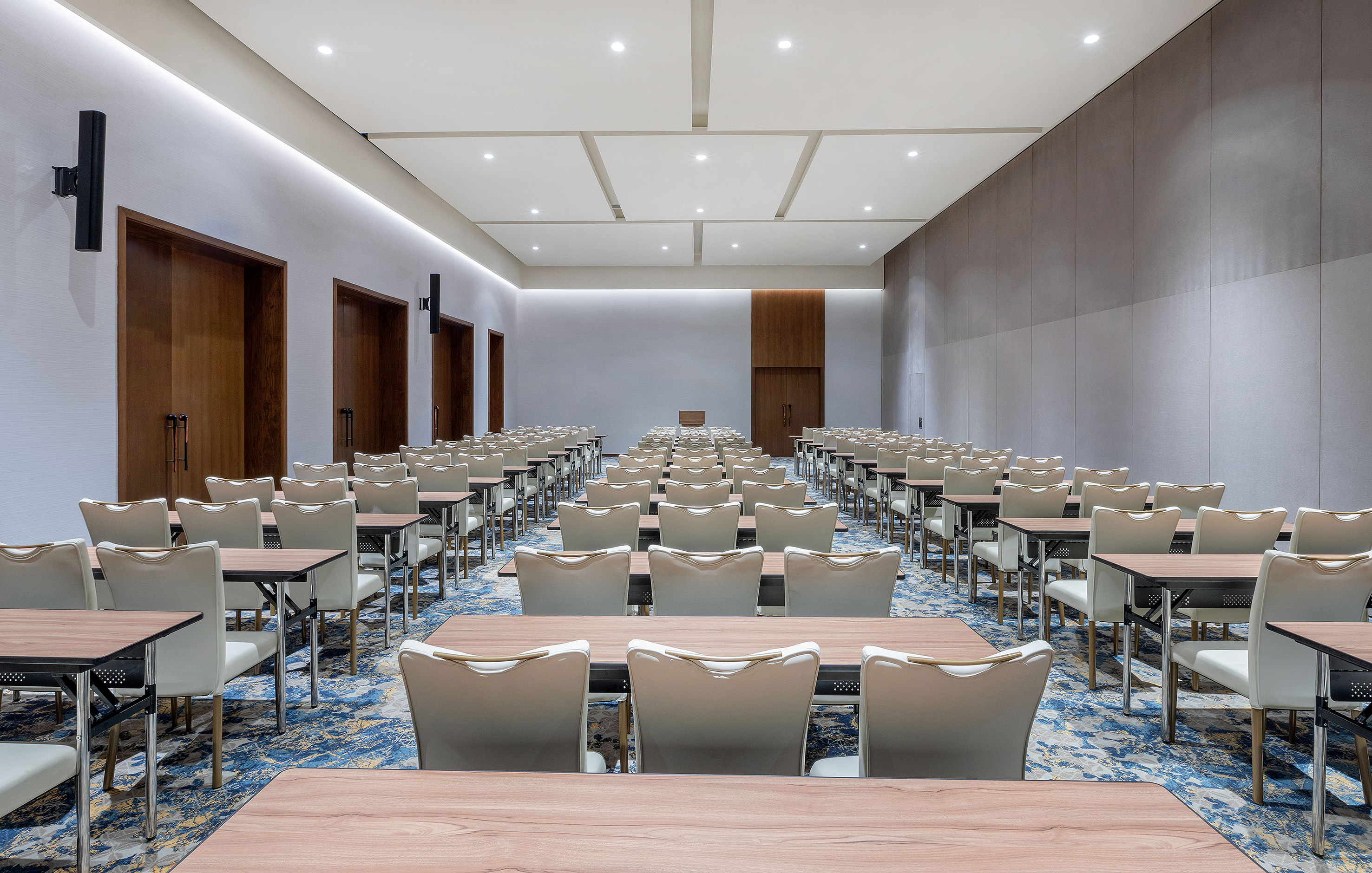 Spacious hotel conference room with classroom setup for events.