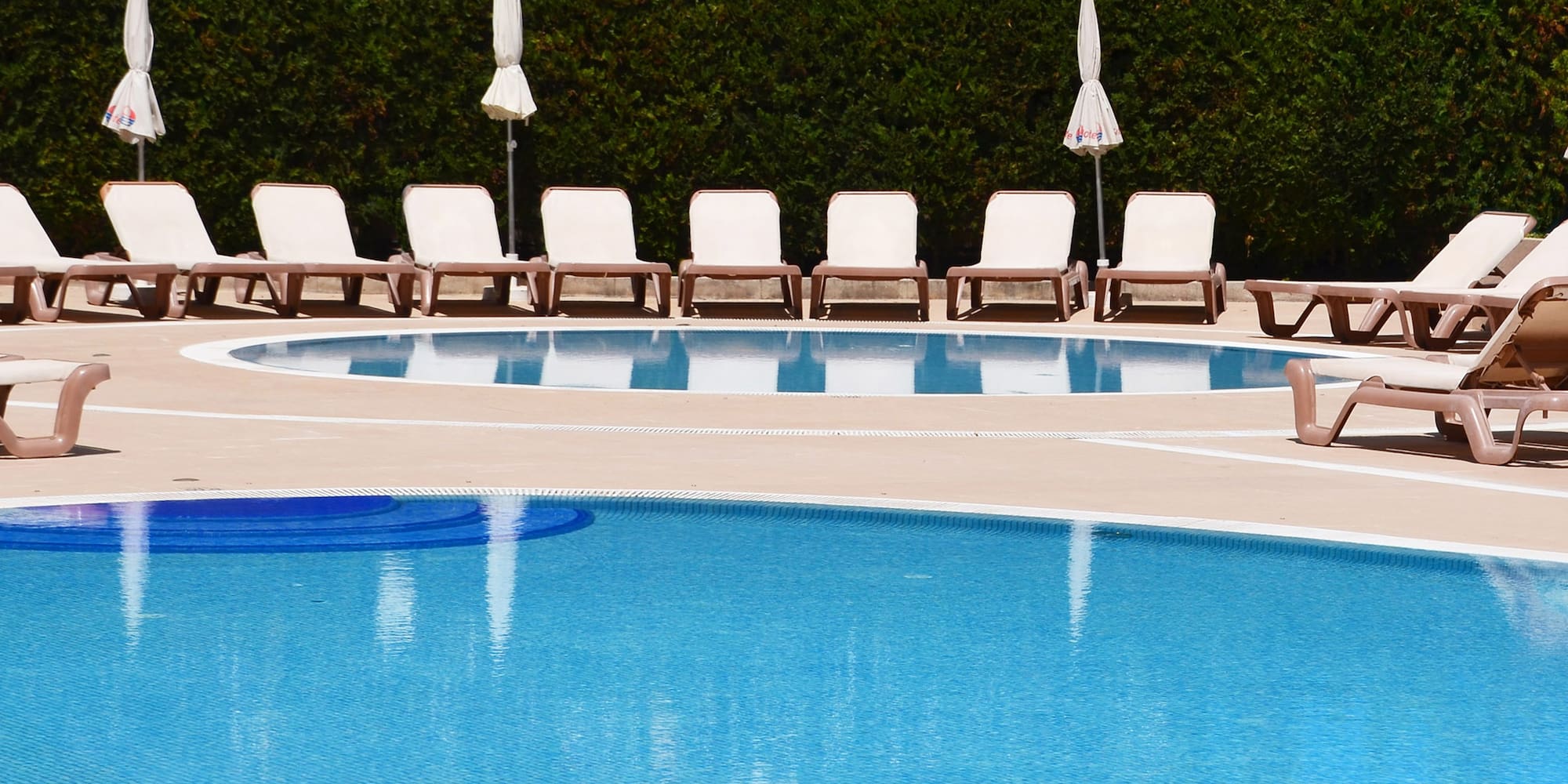 a pool with chairs and umbrellas