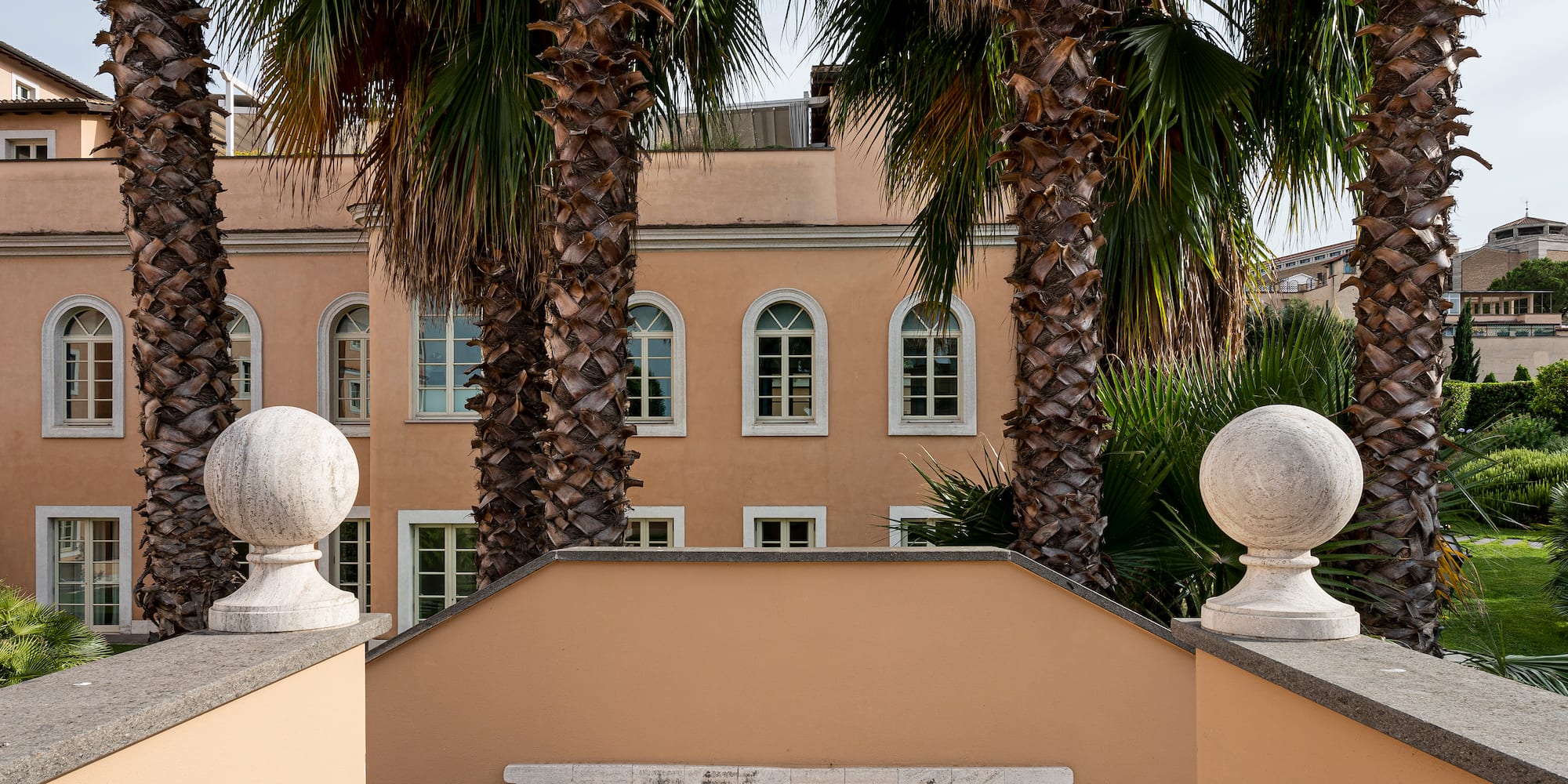 a building with palm trees and a wooden deck
