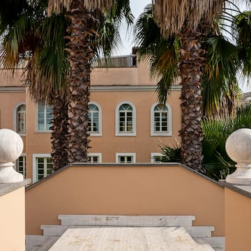 a building with palm trees and a wooden deck