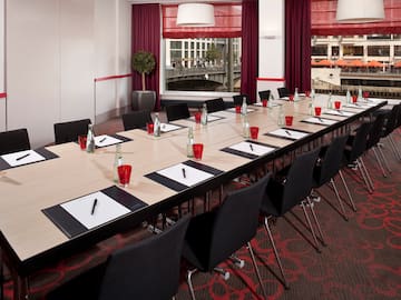 a long conference table with red cups and papers