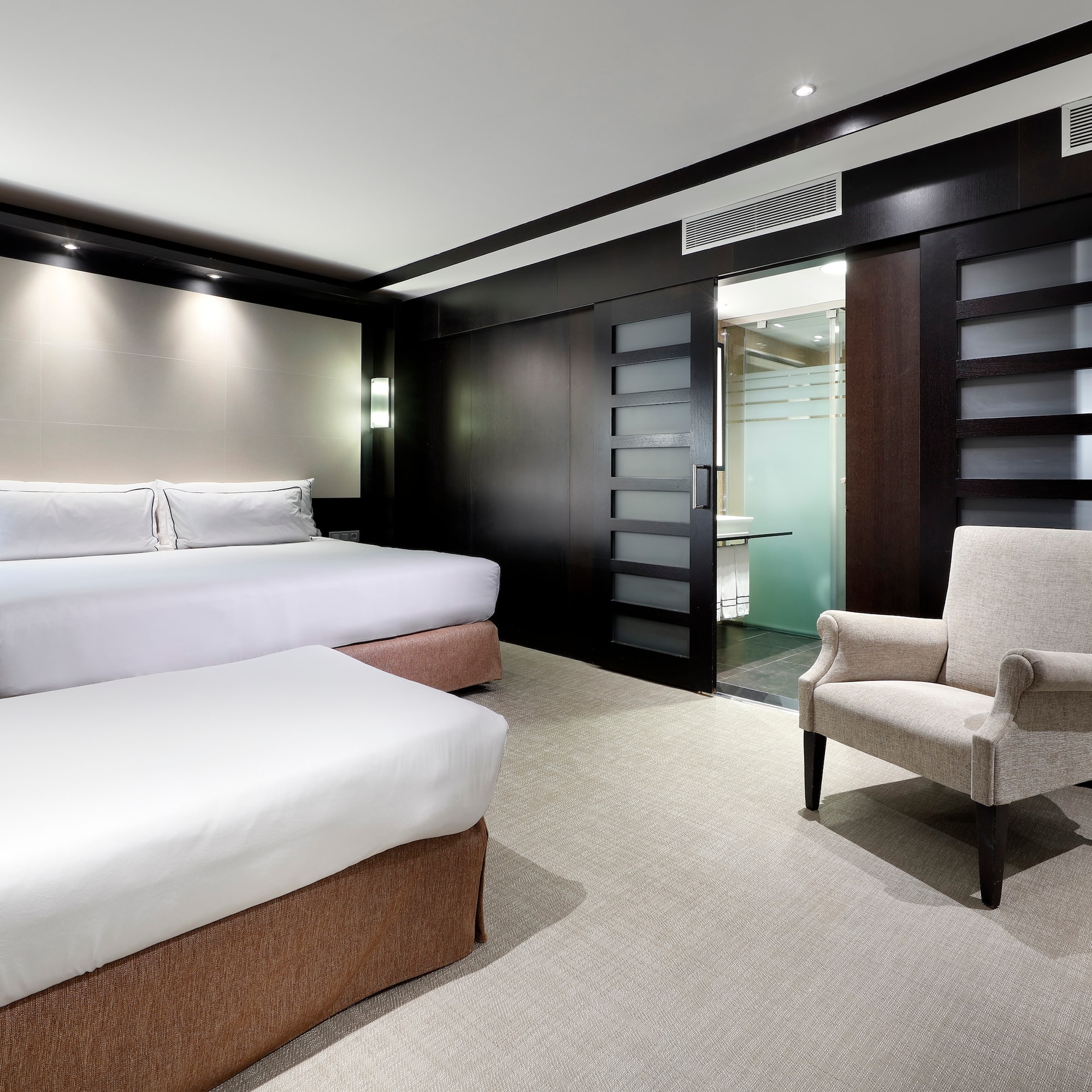 a room with two beds and a chair