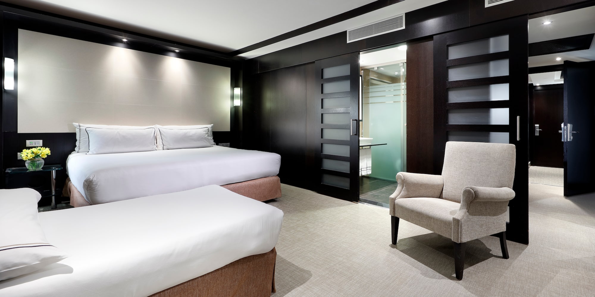 a room with two beds and a chair