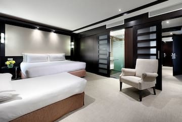 a room with two beds and a chair