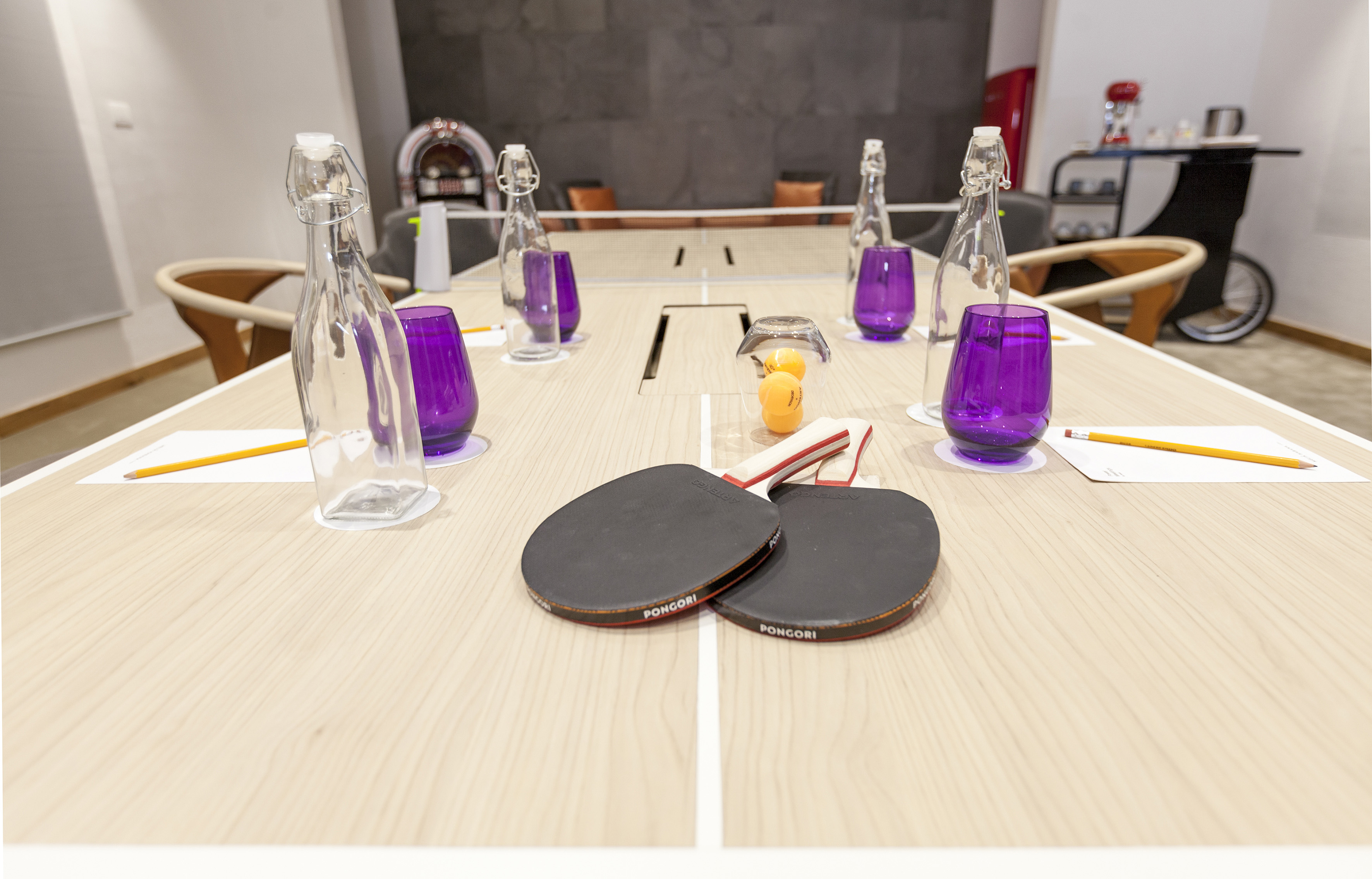 a table with ping pong paddles and purple glasses