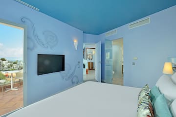 a bedroom with a bed and a television on the wall