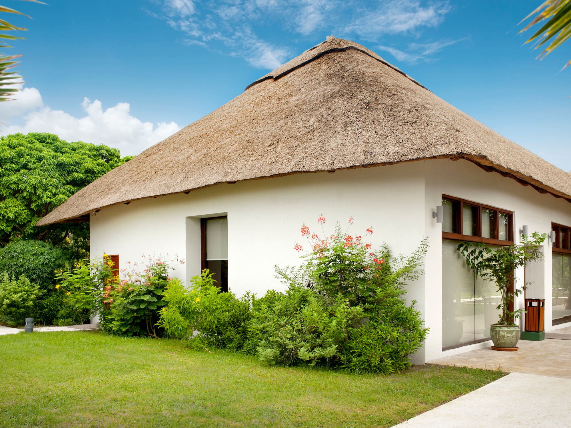 a white house with a thatched roof.