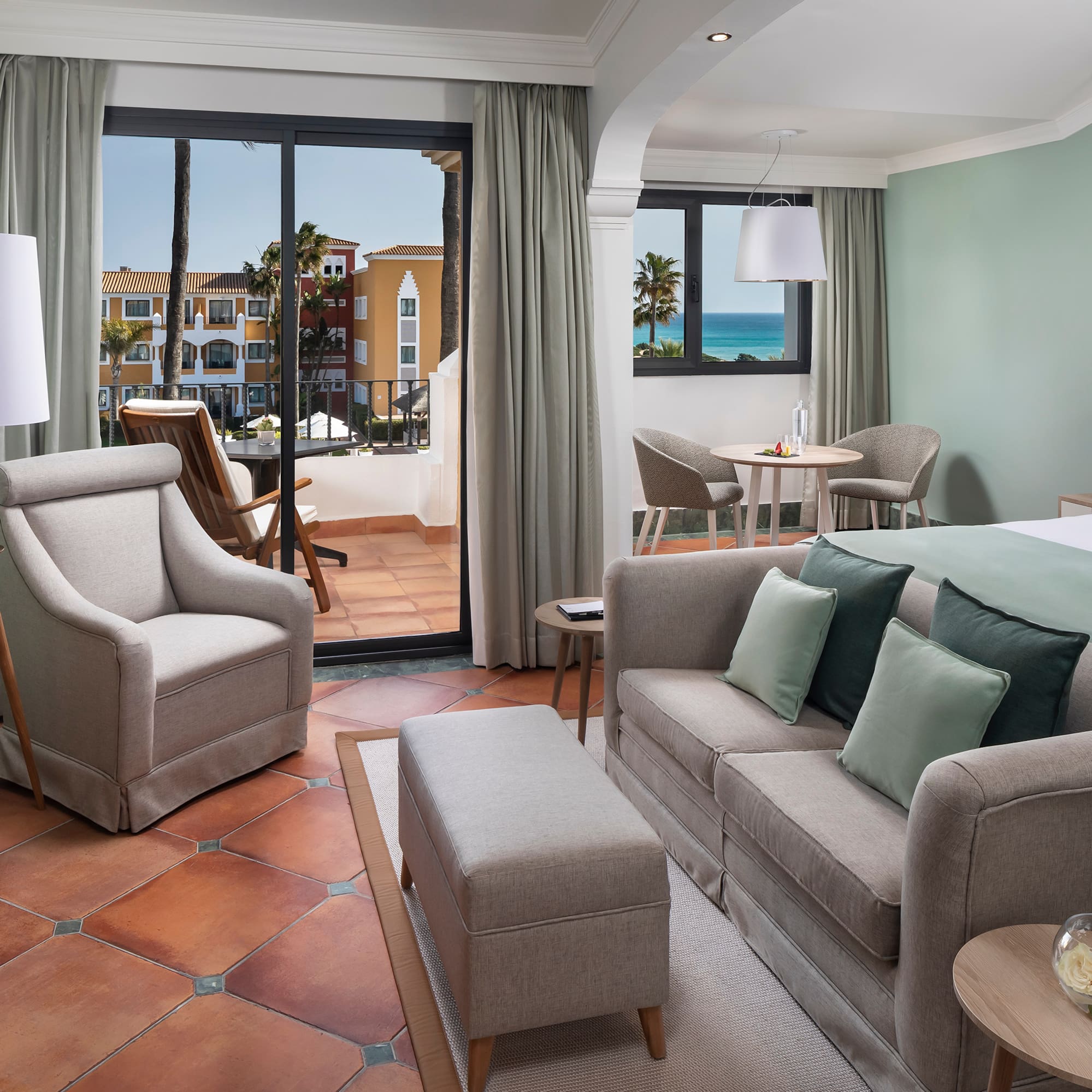 a room with a bed and chairs and a table