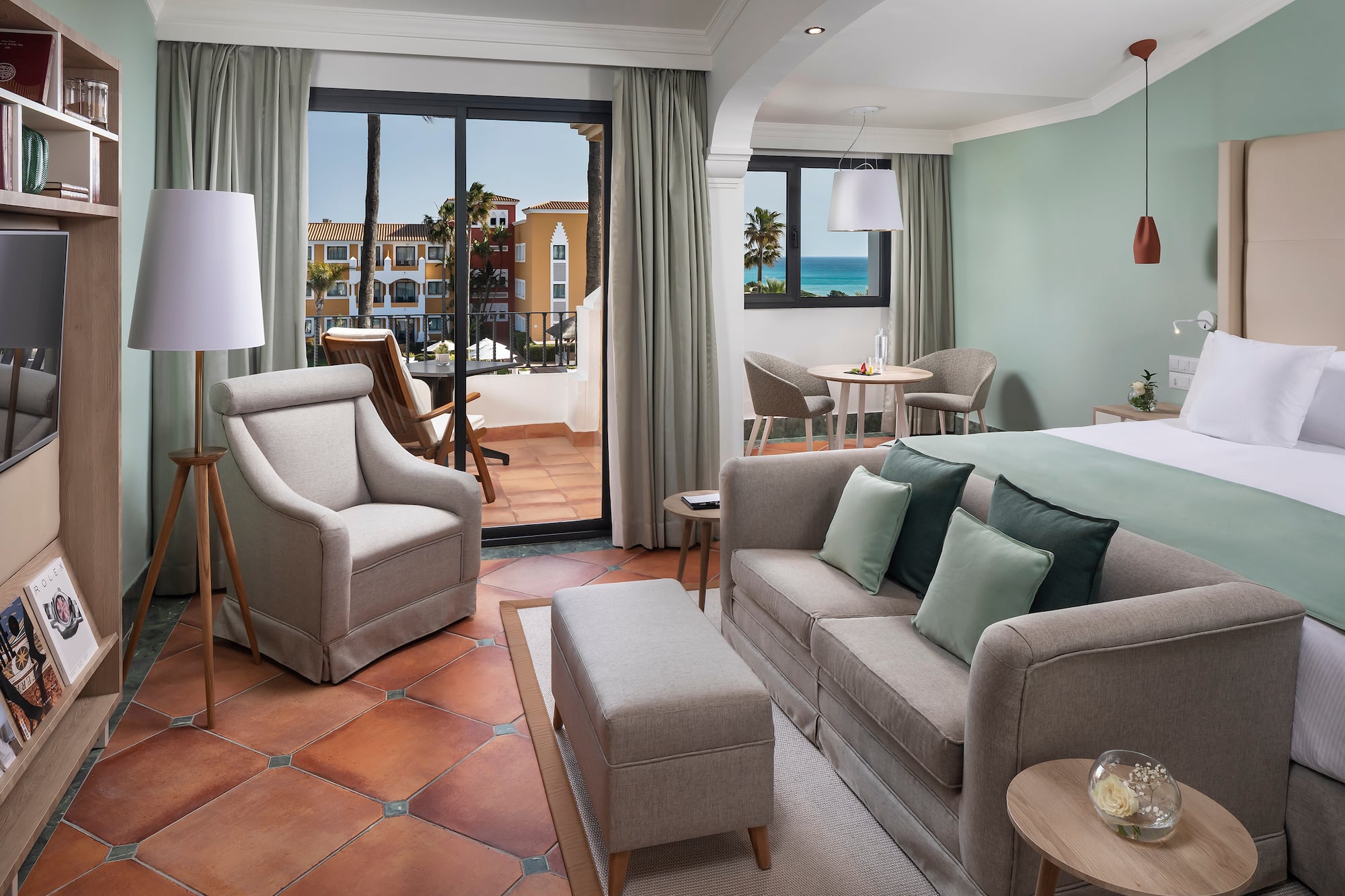 a room with a bed and chairs and a table