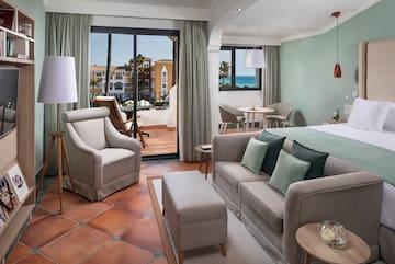 a room with a bed and chairs and a table