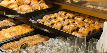 a trays of pastries and glasses on a shelf