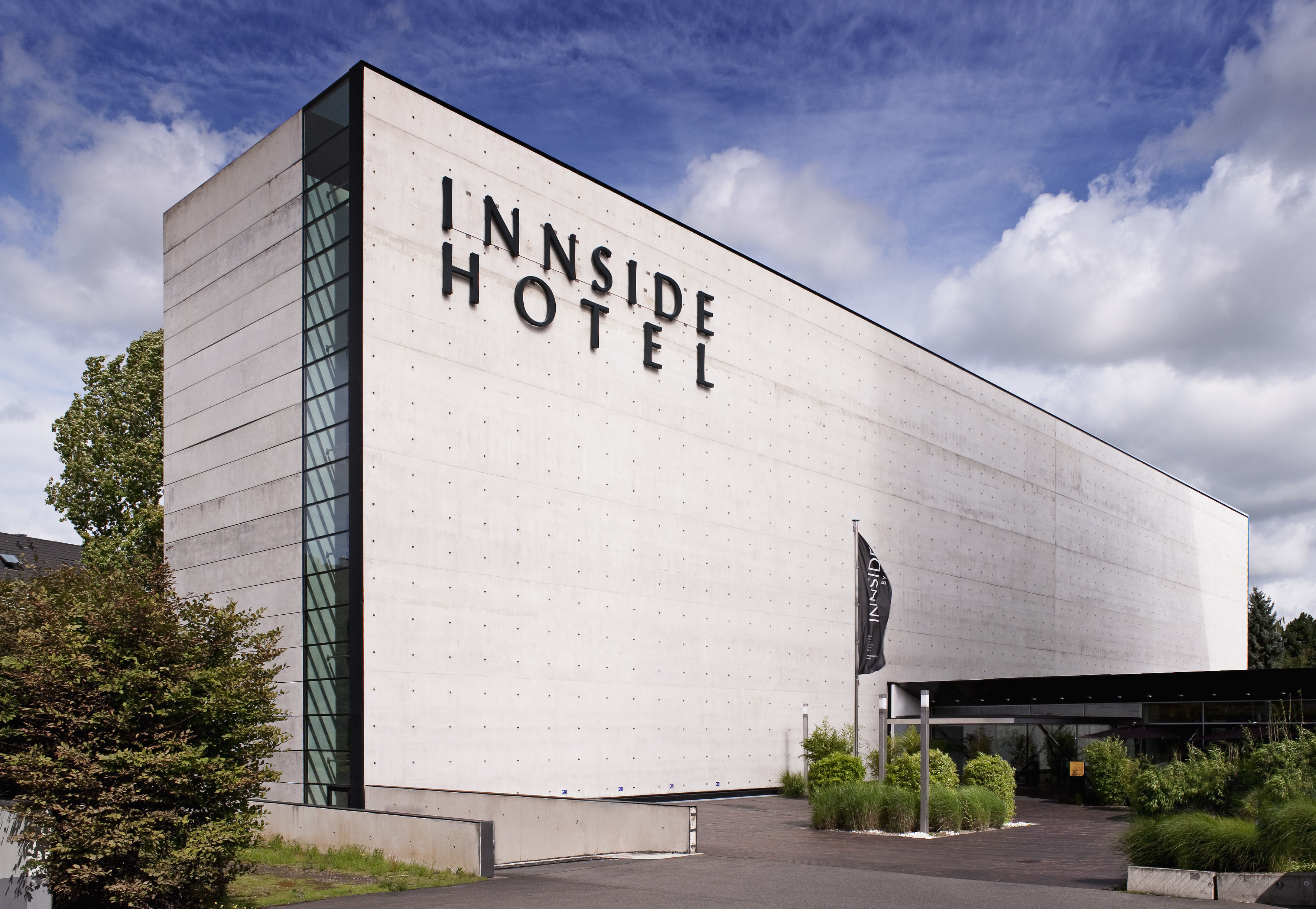 INNSIDE HOTEL exterior: modern concrete building with prominent sign and glass.