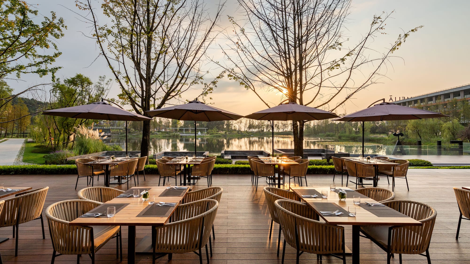 a group of tables and chairs on a deck with umbrellas