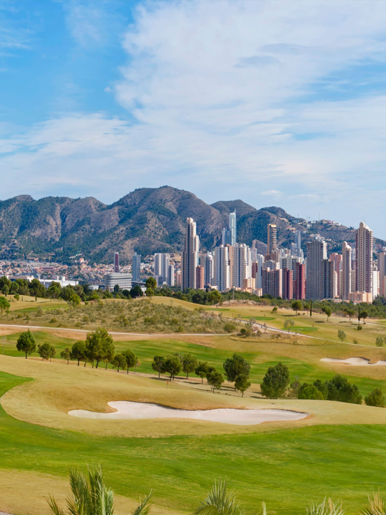 a golf course with a city in the background