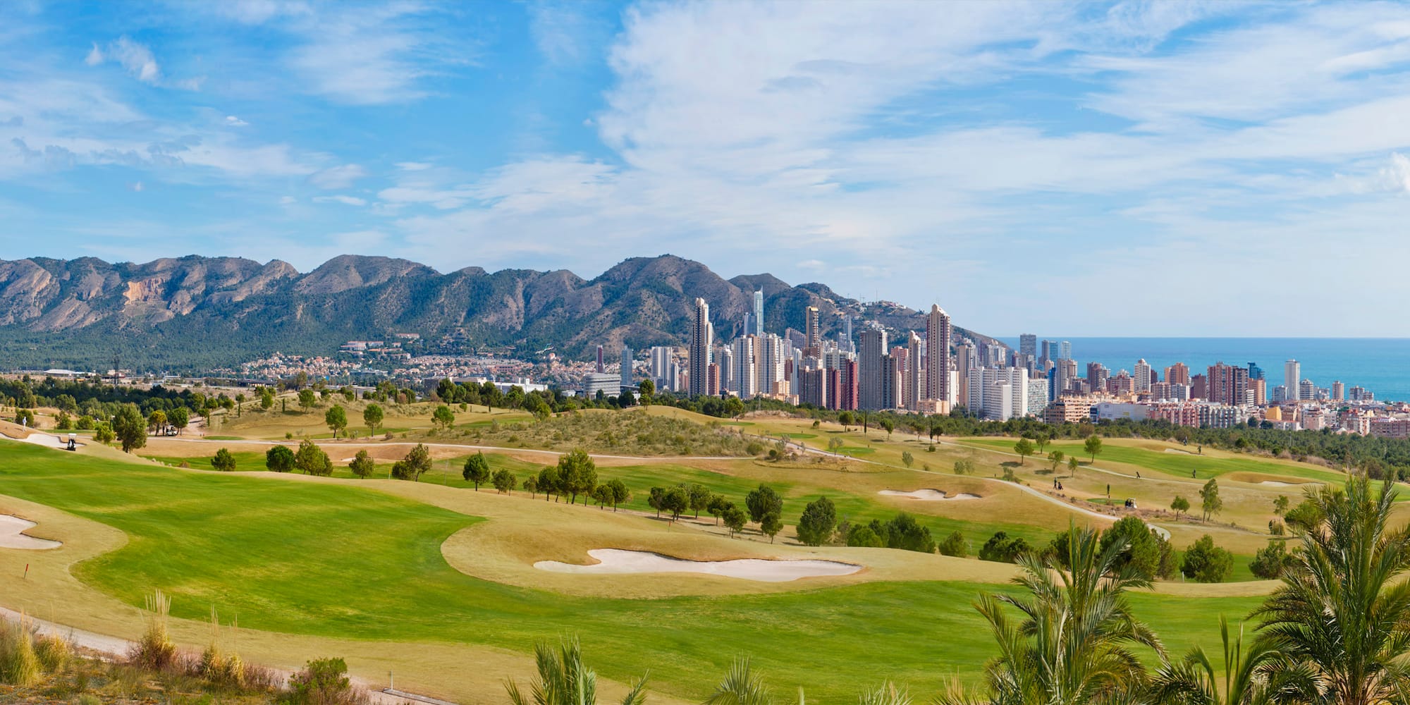 a golf course with a city in the background