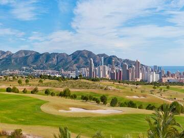 a golf course with a city in the background