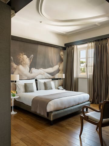 a bedroom with a large painting on the wall