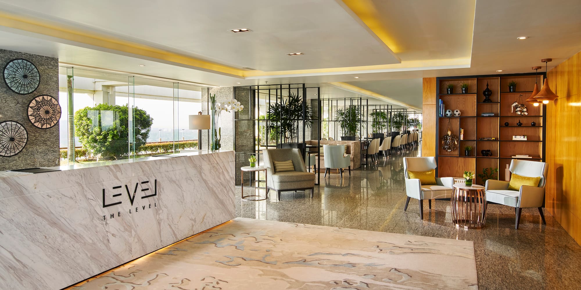 a lobby of a hotel with a marble counter and chairs