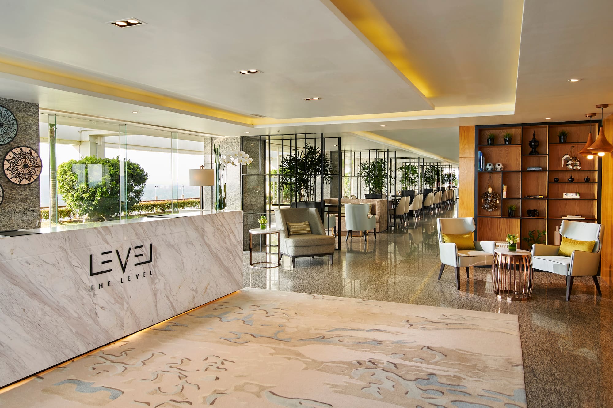 Upscale hotel lobby with 'THE LEVEL' marble reception, modern lounge seating.