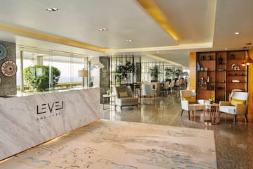 a lobby of a hotel with a marble counter and chairs