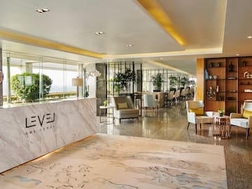 a lobby of a hotel with a marble counter and chairs