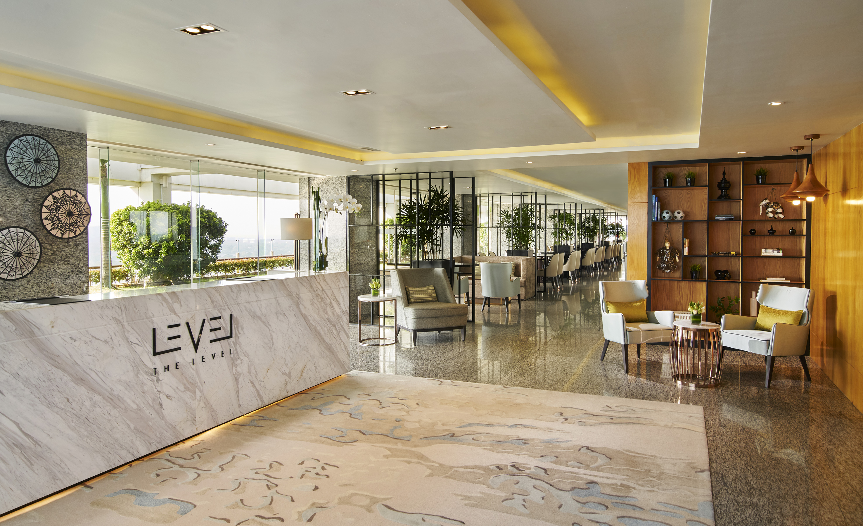 Upscale hotel lobby with 'THE LEVEL' marble reception, modern lounge seating.