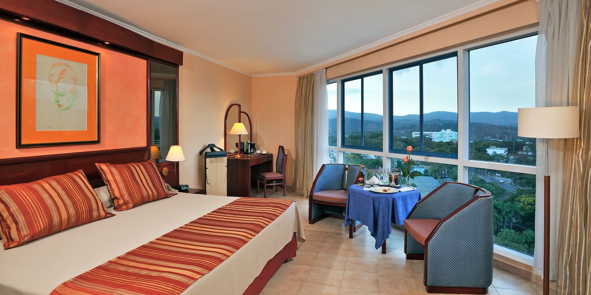 a room with a bed and chairs