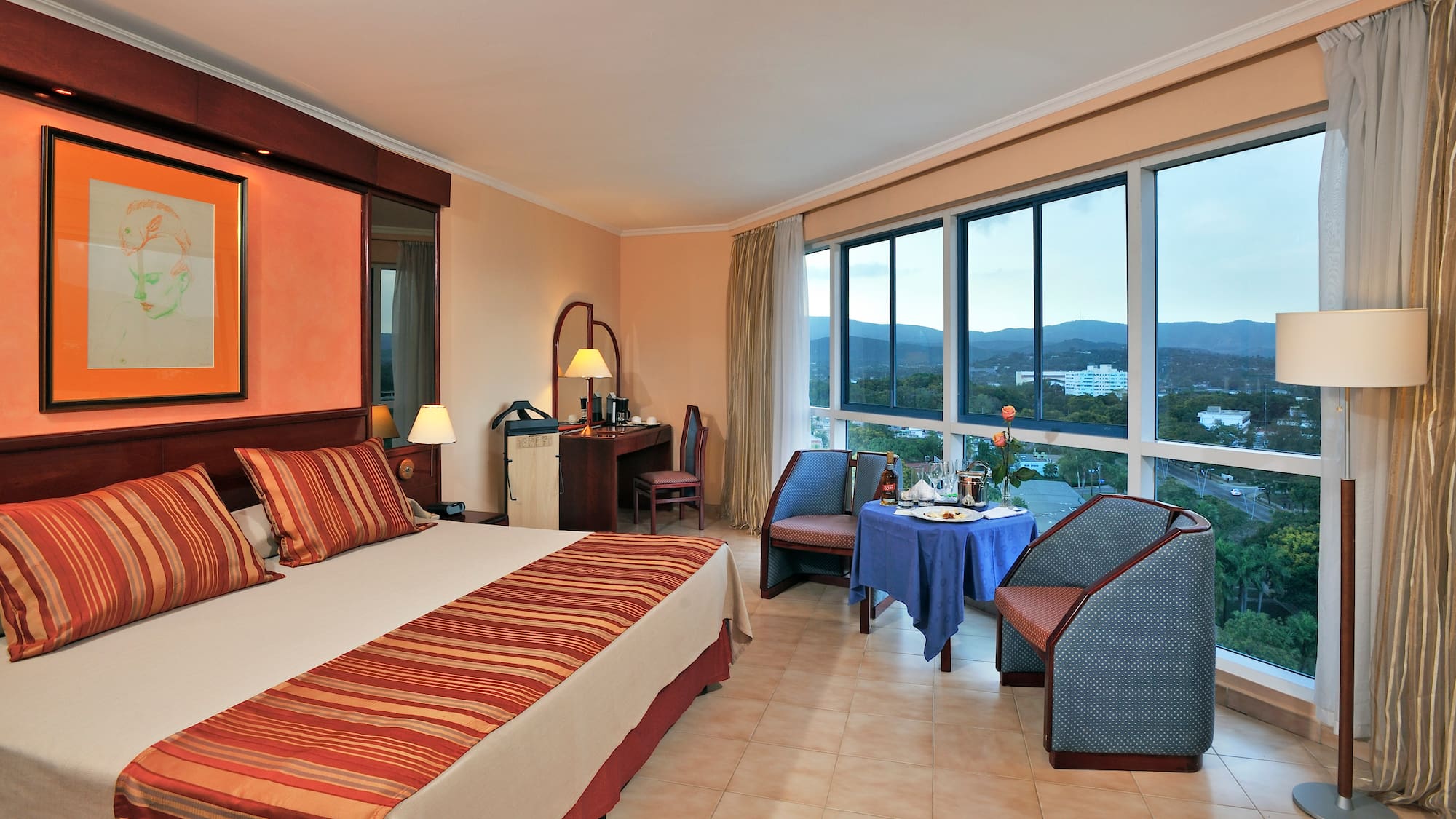 a room with a bed and chairs