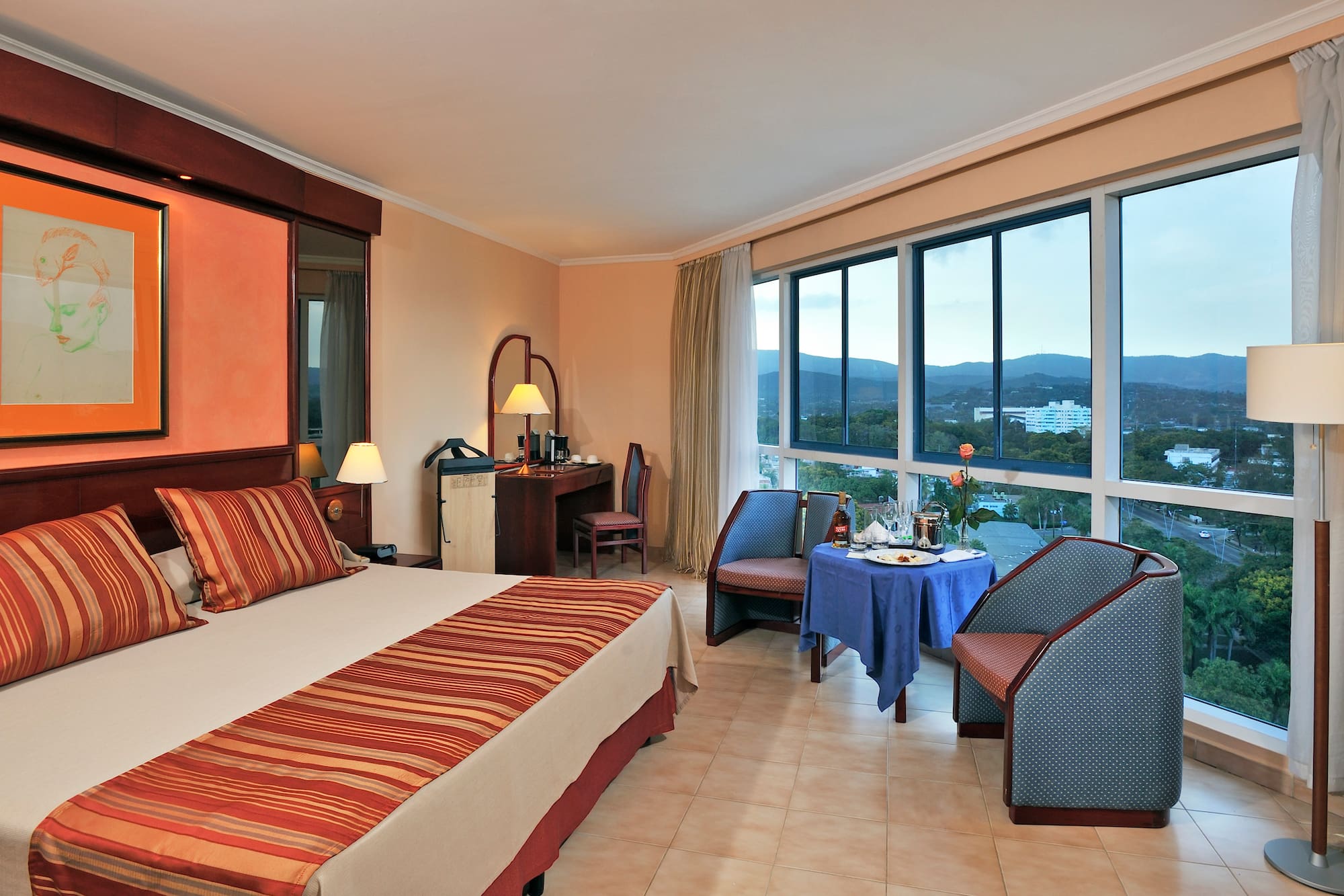 a room with a bed and chairs