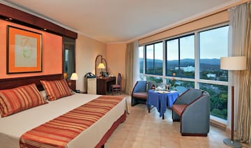 a room with a bed and chairs