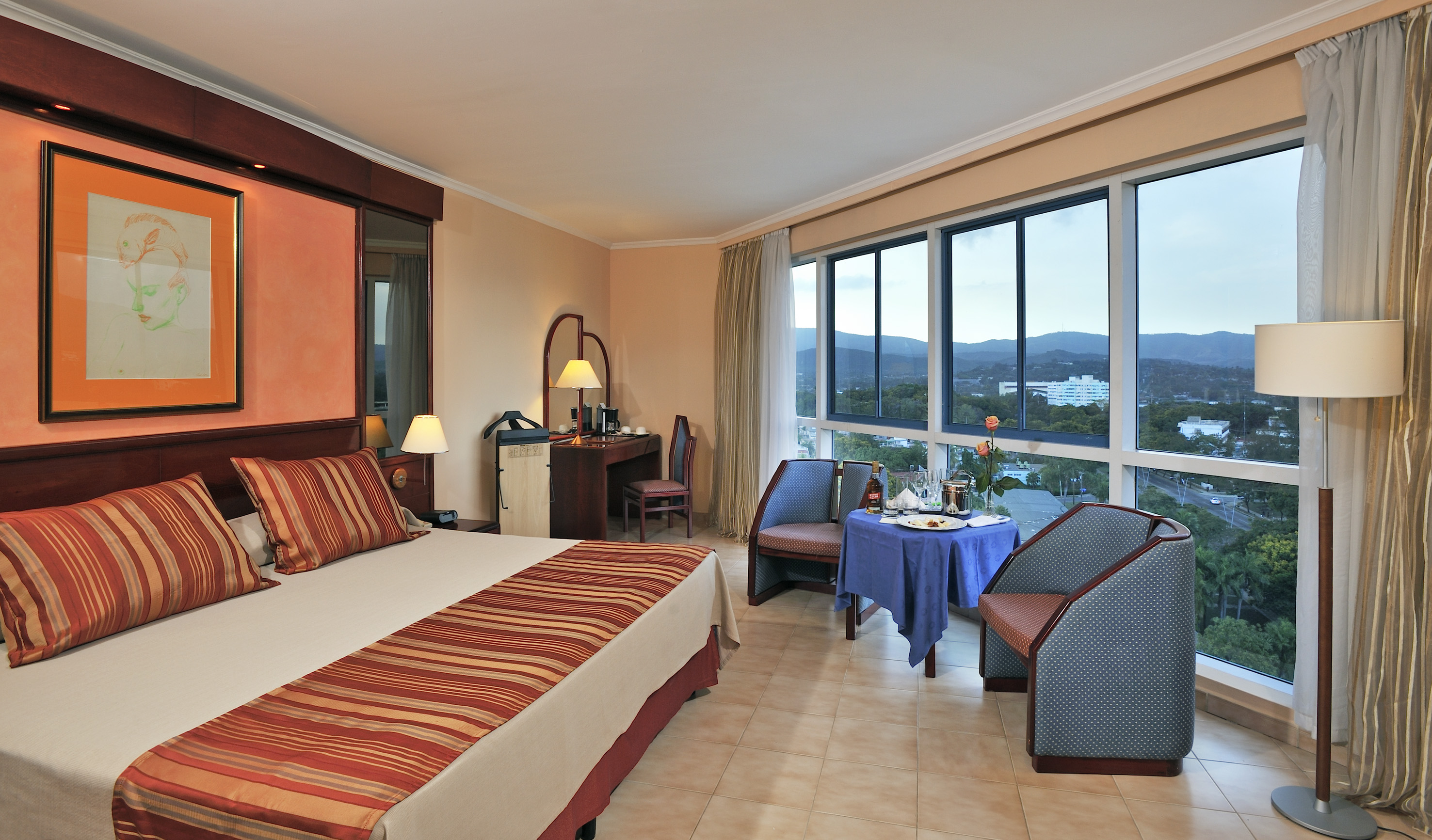 a room with a bed and chairs