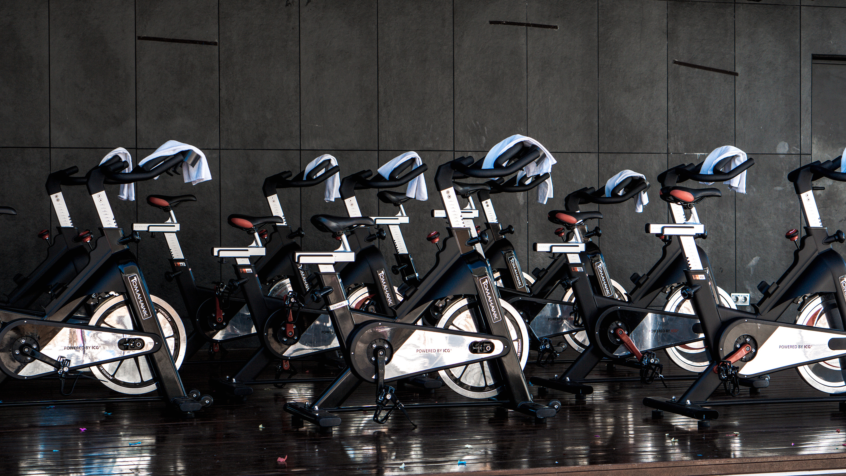 Tomahawk ICG spin bikes with white towels, lined up for a fitness class.
